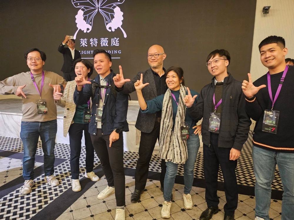G2 會員在活動會場並排合影，眾人比出手勢。